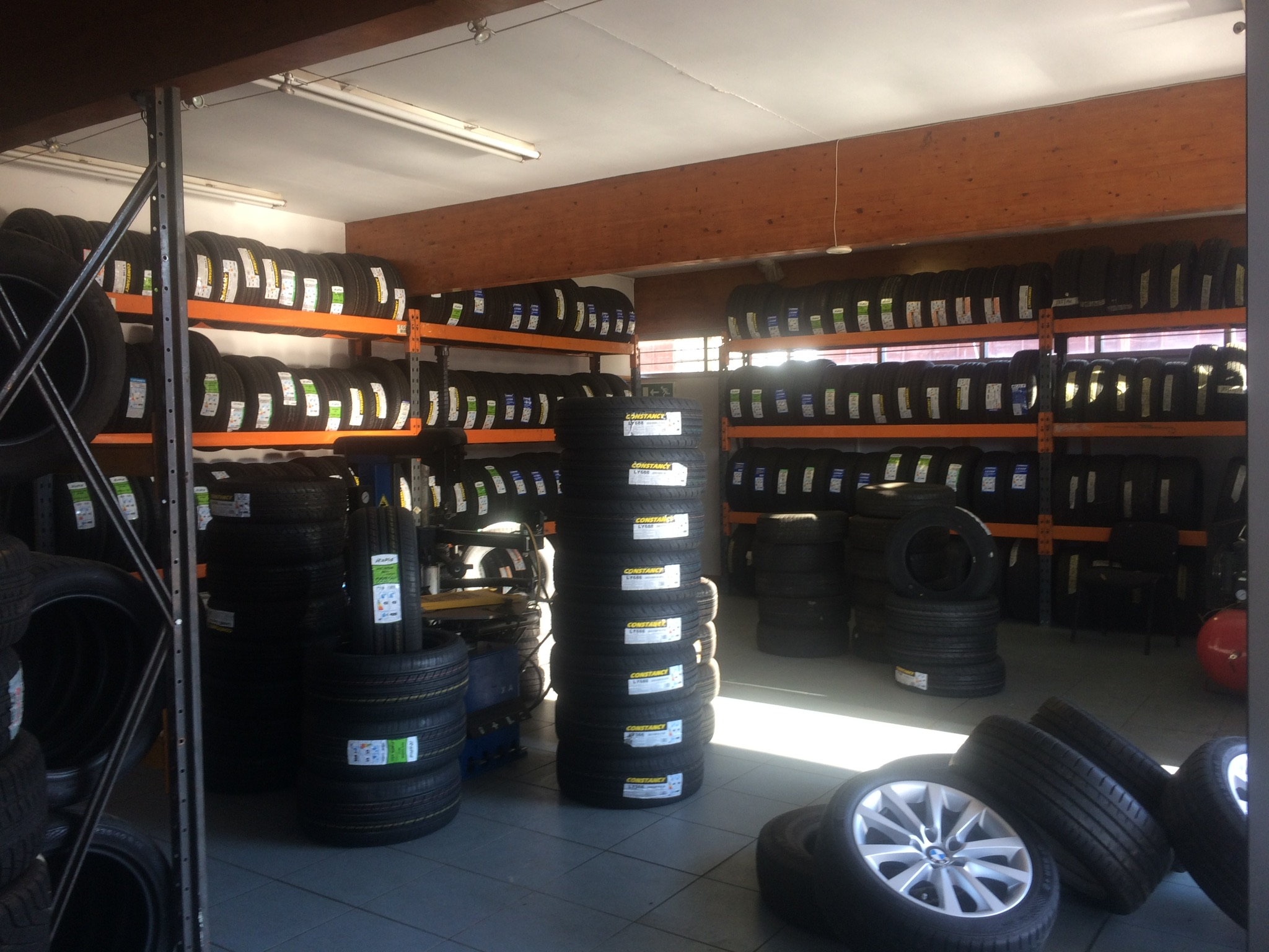 Stacks of tyres and two alloy wheels with tyres inside the shop